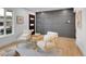 Chic living room featuring modern paneling, wood floors, comfortable seating, and a contemporary front door at 7126 Joan St, Denver, CO 80221