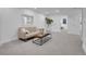 Neutral living room featuring a sofa, coffee table, gray carpet, and a decorative plant at 7126 Joan St, Denver, CO 80221