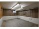 This basement area features concrete flooring, wood paneling, and fluorescent lighting at 13778 W 71St Pl, Arvada, CO 80004