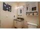 Charming bathroom featuring decorative mirror, storage cabinet and a standard toilet at 13778 W 71St Pl, Arvada, CO 80004