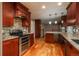 A well-lit kitchen showcasing custom cabinetry, granite counters, stainless appliances, and wood flooring at 13778 W 71St Pl, Arvada, CO 80004