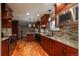 Open kitchen featuring stainless appliances, custom cabinetry, tile backsplash, and granite countertops at 13778 W 71St Pl, Arvada, CO 80004