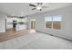 Open-concept living area featuring plush carpeting, natural light, and a view into the kitchen at 2154 Alyssa St, Fort Lupton, CO 80621