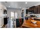 Modern eat-in kitchen with dark cabinetry, stainless steel appliances, and access to the backyard at 19149 E 55Th Ave, Denver, CO 80249