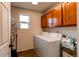 Bright laundry room with washer, dryer, and cabinets at 19149 E 55Th Ave, Denver, CO 80249