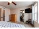 Bright main bedroom featuring a ceiling fan, television, and attached bath at 19149 E 55Th Ave, Denver, CO 80249