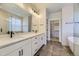 Bathroom featuring double vanity, framed mirror, with tile flooring and walk-in closet at 8946 S Rome Ct, Aurora, CO 80016