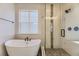 Modern bathroom featuring a sleek tub and a glass-enclosed shower at 8946 S Rome Ct, Aurora, CO 80016