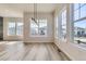 Bright dining room featuring wood floors, large windows, and modern light fixtures at 8946 S Rome Ct, Aurora, CO 80016