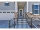 Inviting front porch with gray siding, stone accents, and a black metal railing at 8946 S Rome Ct, Aurora, CO 80016