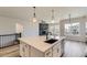 Open-concept kitchen with quartz counters, pendant lights, and stainless appliances, flowing into the living area at 8946 S Rome Ct, Aurora, CO 80016