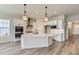 Modern kitchen featuring stainless steel appliances, pendant lighting, and a large island at 8946 S Rome Ct, Aurora, CO 80016