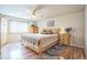 Well-lit bedroom featuring wood floors, a ceiling fan, and ample natural light at 4814 Kingbird Dr, Frederick, CO 80504