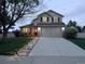 Inviting two-story home featuring a well-manicured lawn, stone walkway, and attached two-car garage at 4814 Kingbird Dr, Frederick, CO 80504