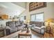 Inviting living room featuring comfortable sofas, wood floors, and abundant natural light at 4814 Kingbird Dr, Frederick, CO 80504