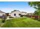 Beautifully landscaped backyard with a well-maintained lawn, garden beds, and a charming bench at 5656 S Sicily Ct, Aurora, CO 80015