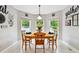 Cozy dining area with wood table and chairs, surrounded by three windows for ample natural light at 5656 S Sicily Ct, Aurora, CO 80015