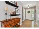 Inviting entryway with hardwood floors, decorative shelving, and a white front door with a wreath at 5656 S Sicily Ct, Aurora, CO 80015