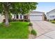 Charming home with a large tree in the front yard and a two-car garage with stone accents at 5656 S Sicily Ct, Aurora, CO 80015