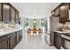 Open-concept kitchen with stainless steel appliances, dark wood cabinets, and a breakfast nook at 5656 S Sicily Ct, Aurora, CO 80015