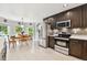 Bright kitchen with stainless steel appliances, dark cabinets, and adjacent dining area with natural light at 5656 S Sicily Ct, Aurora, CO 80015