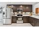 Modern kitchen with stainless steel appliances, dark cabinets, and light countertops at 5656 S Sicily Ct, Aurora, CO 80015