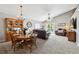Open-concept living room and dining area with vaulted ceilings, neutral paint, and plush carpet at 5656 S Sicily Ct, Aurora, CO 80015