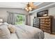 Large primary bedroom with ceiling fan, two dressers, and view of backyard at 5656 S Sicily Ct, Aurora, CO 80015