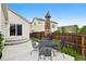 Cozy backyard patio with a table, chairs, umbrella, and a wooden fence at 5656 S Sicily Ct, Aurora, CO 80015