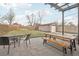 Backyard featuring a brick patio with pergola, fire pit, seating area, and wood picnic table at 4180 S Elati St, Englewood, CO 80110