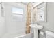 All-white bathroom features a tub, pedestal sink, and decorative shower curtain, creating a clean, classic look at 4180 S Elati St, Englewood, CO 80110