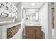 Bathroom featuring wood vanity, granite countertop, framed mirror, decorative towel rack, and tile floors at 4180 S Elati St, Englewood, CO 80110