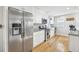 Modern kitchen featuring stainless steel appliances, white cabinetry, and hardwood floors at 4180 S Elati St, Englewood, CO 80110