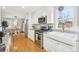 Well-equipped kitchen with stainless steel appliances, white cabinets, and hardwood flooring, adjacent to the dining area at 4180 S Elati St, Englewood, CO 80110