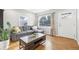 Bright living room with a comfortable gray sectional, hardwood floors, and large windows with stylish curtains at 4180 S Elati St, Englewood, CO 80110
