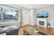 Cozy living room featuring hardwood floors, a decorative fireplace, and a large window that brings in natural light at 4180 S Elati St, Englewood, CO 80110