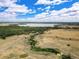 Expansive aerial shot of fields, trails, and a lake under a cloudy blue sky at 9195 E Lehigh Ave # 190, Denver, CO 80237