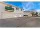 Apartment building featuring garages, second story balcony, and vinyl siding at 9195 E Lehigh Ave # 190, Denver, CO 80237