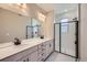 Modern bathroom with double vanity, shower, and white tile at 9657 Browns Peak Cir, Littleton, CO 80125