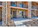 Townhouse entry with stonework, private patio, and dark brown door at 9657 Browns Peak Cir, Littleton, CO 80125