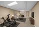 Finished basement featuring exercise equipment, neutral color scheme, and a cozy seating area near stairs at 11704 Elk Head Range Rd, Littleton, CO 80127