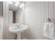 Well lit bathroom with pedestal sink, stylish mirror, and towel holder at 11704 Elk Head Range Rd, Littleton, CO 80127