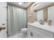 This bathroom includes a white vanity with a modern faucet and a shower and bathtub combination with a patterned curtain at 11704 Elk Head Range Rd, Littleton, CO 80127
