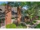 Two-story townhome featuring brick chimney, landscaped entry and mature shade trees at 11704 Elk Head Range Rd, Littleton, CO 80127
