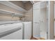 Bright laundry room with side-by-side washer and dryer, storage shelves and wood floors at 11704 Elk Head Range Rd, Littleton, CO 80127
