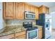 Well-lit kitchen featuring stainless steel appliances, wooden cabinets and granite countertops at 3620 N Saint Paul St, Denver, CO 80205