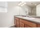 Bathroom featuring a double sink vanity with dark countertops and natural wood cabinetry at 6276 Turnstone Pl, Castle Rock, CO 80104