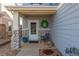 Inviting covered front porch with stone accents, seating, and a decorative wreath at 6276 Turnstone Pl, Castle Rock, CO 80104
