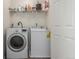 Functional laundry room with a washer, dryer, and storage shelf, offering convenience for laundry tasks at 6276 Turnstone Pl, Castle Rock, CO 80104