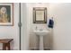 A charming powder room featuring a pedestal sink and decorative mirror at 6276 Turnstone Pl, Castle Rock, CO 80104